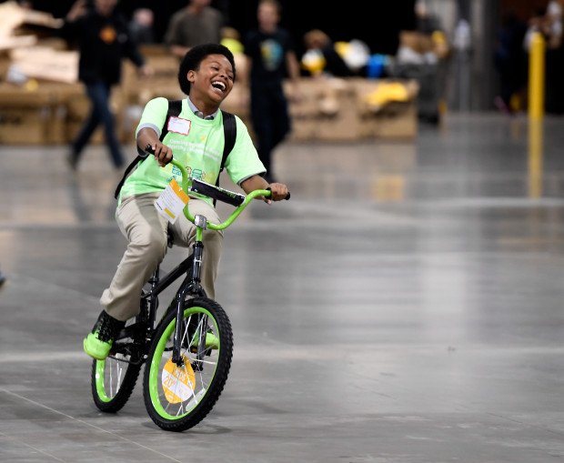 A child’s joy after receiving a bike built by a corporate team — the payoff that makes the experience unforgettable